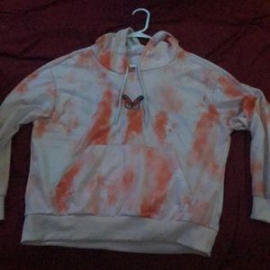 Thin orange and white sweater with a butterfly stitched into the front